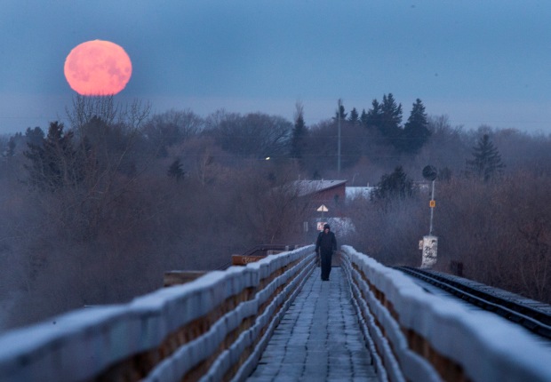 SASKATOON,SK--JANUARY 04/2015--The moon sets behind people crossing the river on 33rd Street pedestrian/train bridge, Wednesday, February 04, 2015.(GREG PENDER/STAR PHOENIX)